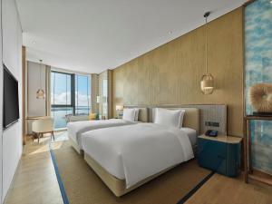 Postel nebo postele na pokoji v ubytování Hilton Hainan Ocean Flower Island + 37 fotografií