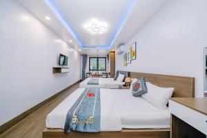 two beds in a room with a blue ceiling at Bao Phuc Hotel in Cat Ba