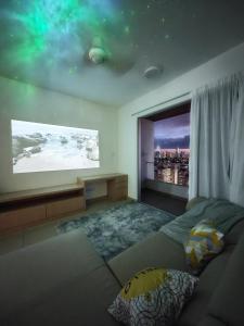 a living room with a large screen tv and a couch at Space Themed KLCC View Condominium @ 6-8 PAX in Kuala Lumpur