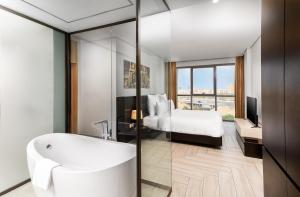 a bathroom with a bath tub and a bedroom at فندق ميروت-Mirot Hotel in Al Khobar