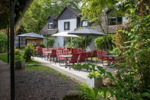 un patio con mesas, sillas y sombrillas en Seminarhotel Jakobsberg en Grünberg