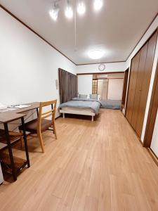 a bedroom with a bed and a desk and a table at 空港＆海遊館直通、2WAYアクセス便利、過客ノ家ー弁天町 in Osaka