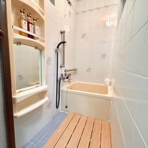 a bathroom with a tub and a sink at 空港＆海遊館直通、2WAYアクセス便利、過客ノ家ー弁天町 in Osaka