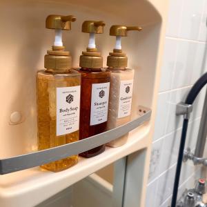 three bottles of soap on a shelf in a bathroom at 空港＆海遊館直通、2WAYアクセス便利、過客ノ家ー弁天町 in Osaka