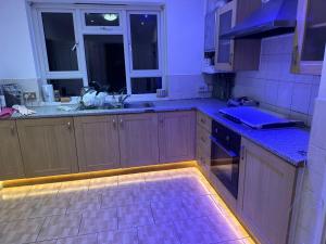 uma cozinha com armários de madeira e bancadas azuis em Tran UK Homestay em Londres