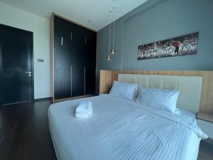 a bedroom with a large bed with two white towels on it at Opus Residences Warisan PNB 118 View in Kuala Lumpur