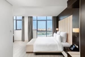 a hotel room with a bed and a large window at Mirot Residence in Al Khobar +86 photos