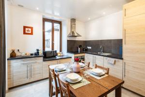 a kitchen with a wooden table and some chairs at Belle Étoile et son Garage privé in Albertville