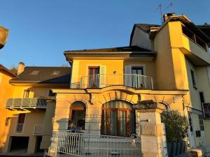 a yellow house with a balcony on top of it at Belle Étoile et son Garage privé in Albertville