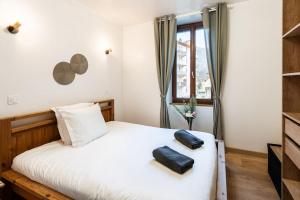 a bedroom with a bed with two black shoes on it at Belle Étoile et son Garage privé in Albertville