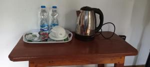 un tavolo con bollitore per tè e bottiglie d'acqua. di Travel rest inn a Ella