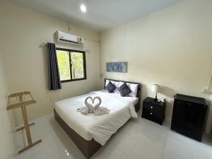 Un dormitorio con una cama con una cinta. en Captain Budget Guesthouse กัปตันเกสต์เฮาส์, en Ko Lipe