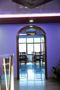 een toegang tot een restaurant met tafels en stoelen bij Hotel Vivid Tawang in Tawang