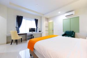een slaapkamer met een bed, een bureau en stoelen bij Sans Hotel 88 Andalan Surabaya by RedDoorz in Surabaya