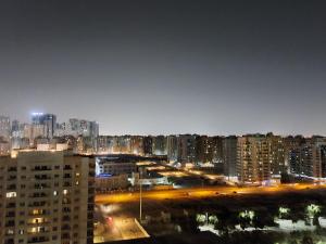 BEAUTIFUL VACATION HOME AT DUBAI BY MAUON TOURISM في دبي: اطلاله على مدينه بالليل بالمباني
