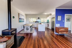 a kitchen and living room with a wood stove at Whale House in Gracetown