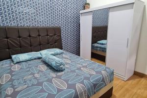 a bedroom with a bed with blue pillows on it at Shazia House - Modern and Cozy Home with 3 Bedrooms and Private Pool in Tanjungkarang