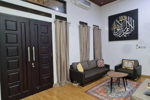a living room with a couch and a door at Shazia House - Modern and Cozy Home with 3 Bedrooms and Private Pool in Tanjungkarang