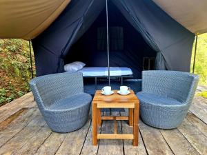 duas cadeiras e uma mesa em frente a uma tenda em Ella Nine Arch Glamp Site em Ella