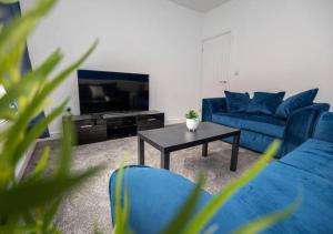 a living room with blue couches and a coffee table at 3 Bedroom Apartment, Fully equipped kitchen - Offer long stays in Lincolnshire