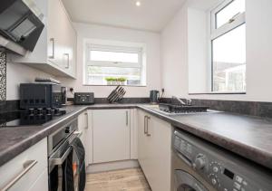 a kitchen with white cabinets and a dishwasher at 3 Bedroom Apartment with non-smoking room - Special big offer for long-term stays in Lincolnshire