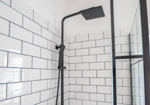 a shower with a light on a white tiled wall at 3 Bedroom Apartment, Fully equipped kitchen - Offer long stays in Lincolnshire