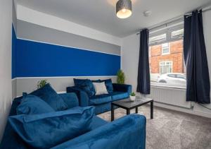 a blue living room with a couch and a table at 3 Bedroom Apartment with non-smoking room - Special big offer for long-term stays in Lincolnshire