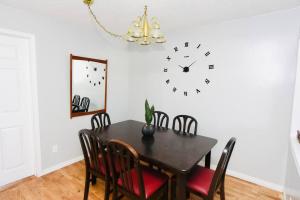 comedor con mesa y reloj en la pared en Spacious perfect 2BR in prime location en Kingston