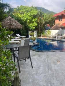 eine Terrasse mit Tisch und Stühlen neben einem Pool in der Unterkunft Tropical Village Resort in Koh Samui 