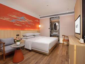 um quarto com uma grande cama branca e uma televisão em Yunju Hotel Beijing Yonghe Palace Guijie Siheyuan em Pequim