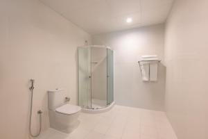een witte badkamer met een douche en een toilet bij Marriott Executive Apartments City Center Doha in Doha