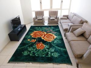 a living room with a green rug with roses on it at PRIVATE ROOM FOR BUSINESS EXECUTIVES BY MAUON TOURISM in Dubai