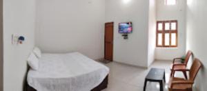 1 dormitorio con 1 cama, 1 silla y TV en HOTEL KALASH GUEST HOUSE AND RESTAURANT Kushinagar en Kushinagar