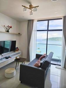 - un salon avec un canapé et une grande fenêtre dans l'établissement Sunset Seaview Studio Apartment at Kota Kinabalu City Centre, à Kota Kinabalu