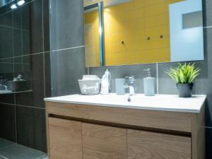 a bathroom with a sink and a shower with yellow tiles at Modern apartment ATG in Athens