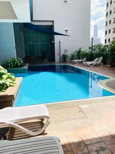 a large swimming pool with chairs in a building at Cool And Cozy Home By Seri Bukit Ceylon Residency in Kuala Lumpur