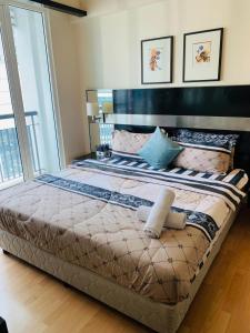 1 cama grande en un dormitorio con ventana grande en Cool And Cozy Home By Seri Bukit Ceylon Residency en Kuala Lumpur