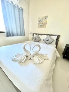 een wit bed met een hartdecoratie erop bij Captain Budget Guesthouse กัปตันเกสต์เฮาส์ in Ko Lipe