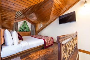 una camera da letto in una baita di tronchi con letto e TV di Summit Grace Boutique Hotel & Spa a Darjeeling