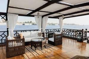 ein Wohnzimmer mit Sofa und Stühlen auf einem Boot in der Unterkunft Farouz El Nil I Nile Cruise - Every Monday from Luxor for 07 & 05 Nights in Ţawd
