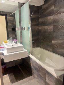 Luxurious 2 Bedroom 5 Mins from Burj Khalifa في دبي: حمام مع حوض وحوض استحمام