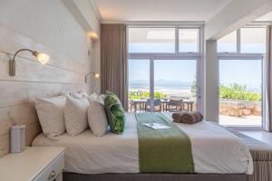 a bedroom with a bed with a view of the ocean at Lookout Lodge in Plettenberg Bay