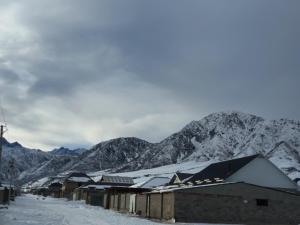 un villaggio ricoperto di neve con montagne sullo sfondo di Terrabella a Bishkek