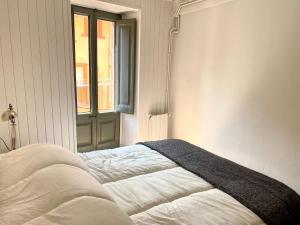 Un dormitorio con una cama con una manta. en l'Apartament de la Plaça, en Puigcerdà