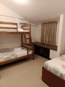 a room with two bunk beds and a desk at Elisha's Guest House in Coron