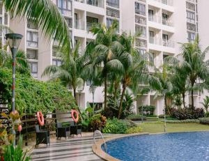 um resort com piscina, palmeiras e um edifício em Country Garden Danga Bay Studio Unit by KS em Johor Bahru