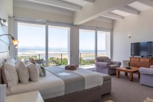 a bedroom with a large bed with a view of the ocean at Lookout Lodge in Plettenberg Bay