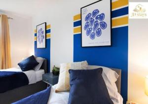 1 dormitorio con cama y pared azul en 3 Bedroom Apartment, family & business - Big special offer for long stays en Lincolnshire