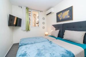 1 dormitorio con 1 cama azul y blanca y TV en HEITEA LODGE - 6 min airport, Wifi, AC & Parking, en Papeete