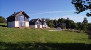 a house on a hill with a green field at Domki Blisko Nieba I in Wisła